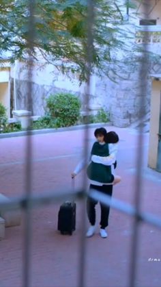 a woman is walking down the street with her luggage