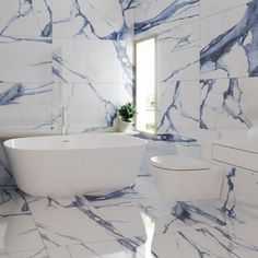 a white and blue marble bathroom with a tub