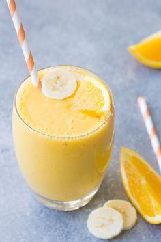 a smoothie with bananas and orange slices on the side