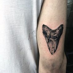 a man's arm with a black and white tattoo of a bat on it