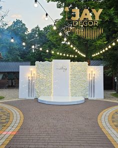 an outdoor ceremony setup with white flowers and string lights