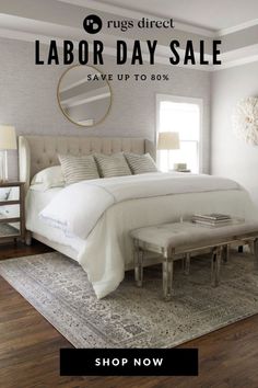 a bed with white sheets and pillows on top of it next to a rug that reads labor day sale save up to 80 %