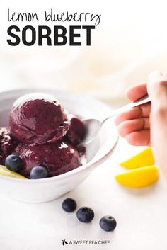 a bowl filled with blueberry sorbet next to lemon wedges