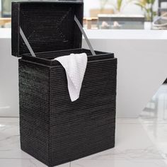 a black wicker box with a white towel hanging from it