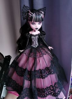 a doll is dressed in black and pink