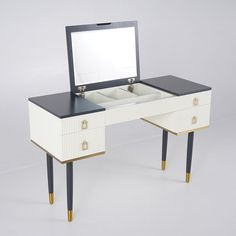 a white and black vanity with mirror on it's side table next to two legs