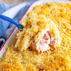 a casserole dish with ham and cheese on it is being scooped from the casserole