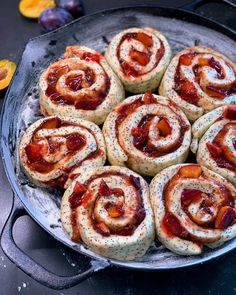 a pan filled with pastries sitting on top of a table next to sliced oranges