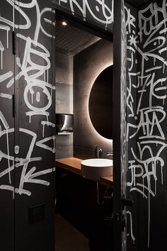 a bathroom with graffiti written all over the walls and around the sink area is shown