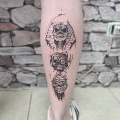 a tattoo on the leg of a person with an elephant head and two skulls in it