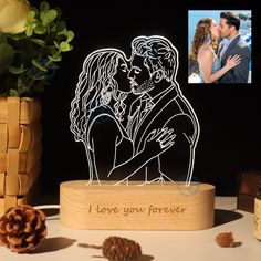 a wooden stand with a cutout of a man and woman kissing in front of a pine cone