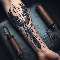 a person with a tattoo on their arm next to thread spools and scissors