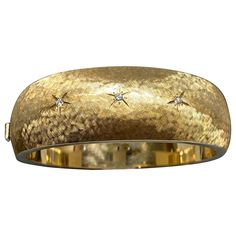 Up for your consideration is this fantastic heavy 14kt yellow gold hinged bangle bracelet circa 1960's. This big, bold, and beautiful wide convex wrist bangle, is crafted in gleaming 14K yellow gold in a stunning florentine textured finish. The front is sprinkled with three small sparkling round brilliant cut diamonds inset into the bangle with etched starburst accents. This is a fabulous piece that is great on it's own or layered with other bracelets in a stack. It would be an excellent and timeless addition to any wrist, collection and jewelry box. It is in very very good condition and very comfortable to wear. Closes with push clasp and safety catch. Diamond weight - .10 cttw, VS2, G-H color .82" at it's widest and tapers to .57" at the back 6 5/8" interior measurement Marked 14k Weight Hinged Bangle, Round Brilliant Cut Diamond, Bangle Bracelet, Round Brilliant, Arm Band, Hinges, Bangle Bracelets, Jewelry Box, Jewelry Bracelets