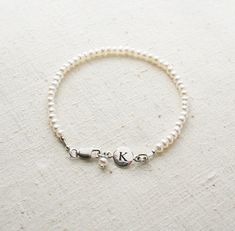 Bridesmaid Bracelet, Pearl Bracelet, Initial Bracelet, Personalized Jewelry, Bridesmaid Gift There are oodles of pearls on these bracelets. They make a lovely gift for your bridesmaids. One that they can wear well after your wedding day! + Small Freshwater Pearls (size of pearls are approx. 3mm) Sterling Silver Initial & Lobster Clasp. + Initial: Pick upon checkout. + Bracelet Length: Pick upon checkout. + Your jewelry will come in a jewelry box, tied with a ribbon, ready for gift giving. Th Classic Personalized Adjustable Pearl Bracelet, Personalized Adjustable Classic Pearl Bracelet, Classic Adjustable Personalized Pearl Bracelet, Elegant Silver Name Bracelet With Round Beads, Adjustable Pearl Drop Bracelet For Weddings, Adjustable Pearl Wedding Bracelet, Dainty Wedding Jubilee Charm Bracelet, Personalized Round Bead Pearl Bracelet In Elegant Style, Elegant Personalized Round Bead Pearl Bracelet