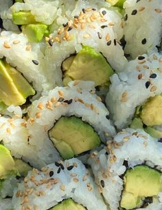 sushi rolls with avocado and sesame seeds on them are ready to be eaten