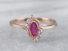 "This ruby ring is classic with a twist! The marquise cut of the ruby is flattering on the hand, with diamond accents that add lots of sparkle. Bypass style shoulders create a sense of movement and bring this ring to life! Metal: 14K Rose Gold Gem: Ruby .20 Carats Gem Measurements: 3.1 x 6 mm, Marquise Cut Accents: 6 White Sapphires totaling .15 Carats Ring Size: 8.25 Marks: \"14K China\" Stamped on the inside band SKU #: 8NU3KZX6 Each piece has been identified and graded by a Graduate Gemologis Ruby Ring Designs, Real Diamond Earrings, Gem Ruby, Gold Finger Rings, Ring Rosegold, Gold Plated Bangles, Coral Ring, Victorian Rings, Gold Earrings Designs