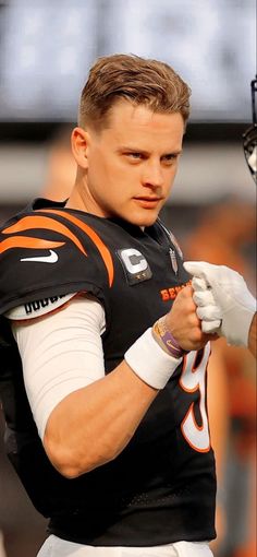 a close up of a football player holding his hands on his chest and looking at the camera