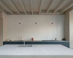 an empty kitchen with white walls and blue counter tops is seen in this image, there are no people around