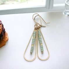 Add a touch of fun and femininity with our Harley gold teardrop earrings, adorned with delicate mint green seed beads. Perfect for any occasion (and any outfit), these long earrings will complete your look and add a hint of whimsy to your style. A must-have for any accessory lover! Approximately 2.25” long Made with 14k Gold Filled Light Mint Green Seed Beads Polished to a high shine Handmade in Montana Sent in a ribboned gift box with polishing cloth Light Mint Green, African Turquoise, Jewelry Packaging, Long Earrings, Teardrop Earrings, Mint Green, Gold Filled, Seed Beads, Mint