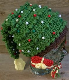 a crocheted christmas tree hat on top of a mannequin head