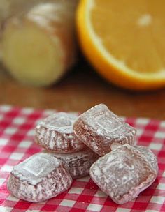 some sugary treats are on a red and white checkered tablecloth next to an orange