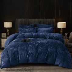 a bed with blue comforters and pillows in a room