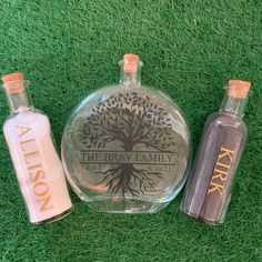 three personalized liquor bottles sitting on the grass