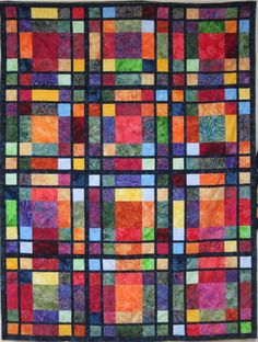 a multicolored quilt hanging on the wall