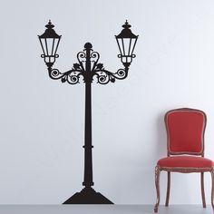 a red chair sitting next to a black lamp post wall decal on a white wall