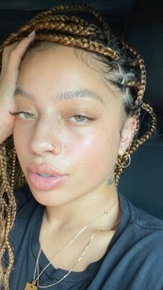 a woman with braids in her hair sitting in the back seat of a car