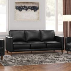 a living room with two black leather couches