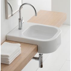 a white sink sitting on top of a wooden counter next to a towel dispenser