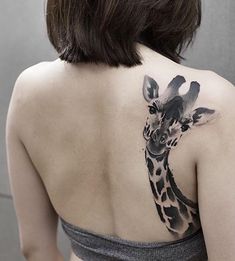 a woman with a giraffe tattoo on her back