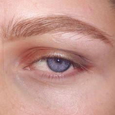 a close up of a person's eye with brown hair