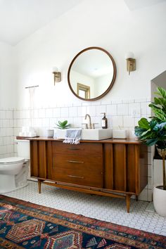 a bathroom with a sink, mirror and rug