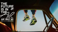 a pair of shoes hanging from the side window of a car with an advertisement for air max 90