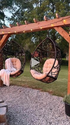 two hanging chairs in the middle of a yard