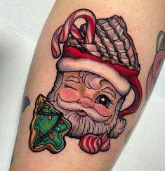 a tattoo with a santa clause holding a candy cane