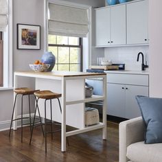 a kitchen island with two stools in front of it