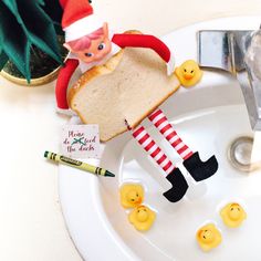 an elf is sitting on top of a piece of bread with rubber ducks in front of it