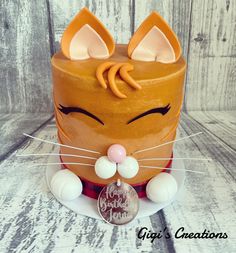 a cat cake with ears and eyes on a plate