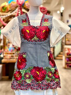 a mannequin wearing a dress with red flowers on it's chest and sleeves