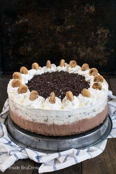 a cake with white frosting and chocolate chips on top is sitting on a plate