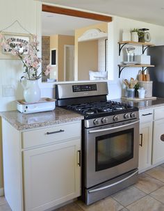 a stove top oven sitting inside of a kitchen next to a microwave and countertop