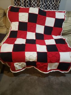 a red and black blanket sitting on top of a couch