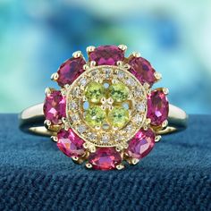 This ring presents a striking and luxurious appearance. The centerpiece is a vibrant floral-inspired design, featuring lime green peridot surrounded by vivid pink tourmaline gems and diamonds, creating a flower-like pattern. The contrast between the soft green center and the bold pink petals is visually captivating. The setting appears to be crafted in gold, which provides a warm, lustrous backdrop for the colorful gemstones.This piece would likely appeal to those who appreciate nature-inspired jewelry designs with a touch of vintage or romantic flair. CHARACTERISTICS Status: Made to order Origin: Thailand Metal: Solid 9K Yellow Gold Ring Size: US 3-8 Total Gemstones Weight: 1.88 carat. (approx.) Total Gram Weight: 4.50 g. (approx.) *Pictures have been enlarged to show details* PRIMARY STO Luxury Multicolor Cluster Ring With Accent Stones, Luxury Tourmaline Jewelry With Gemstone Accents, Luxury Multicolor Diamond Gemstones, Unique Luxury Peridot Rings, Luxury Peridot Gemstones With Gemstone Accents, Luxury Multicolor Multi-stone Diamond Ring, Luxury Yellow Gold Multi-stone Amethyst Ring, Peridot Color, Colorful Gemstones