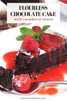 a piece of chocolate cake with raspberry sauce on a white plate next to some strawberries