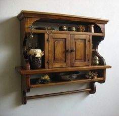 a wooden shelf with some pots and pans hanging on it's side wall