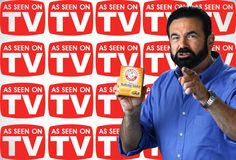 a man holding up a box of tv soap in front of a red and white background