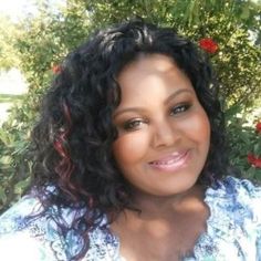 a woman with curly hair smiling for the camera